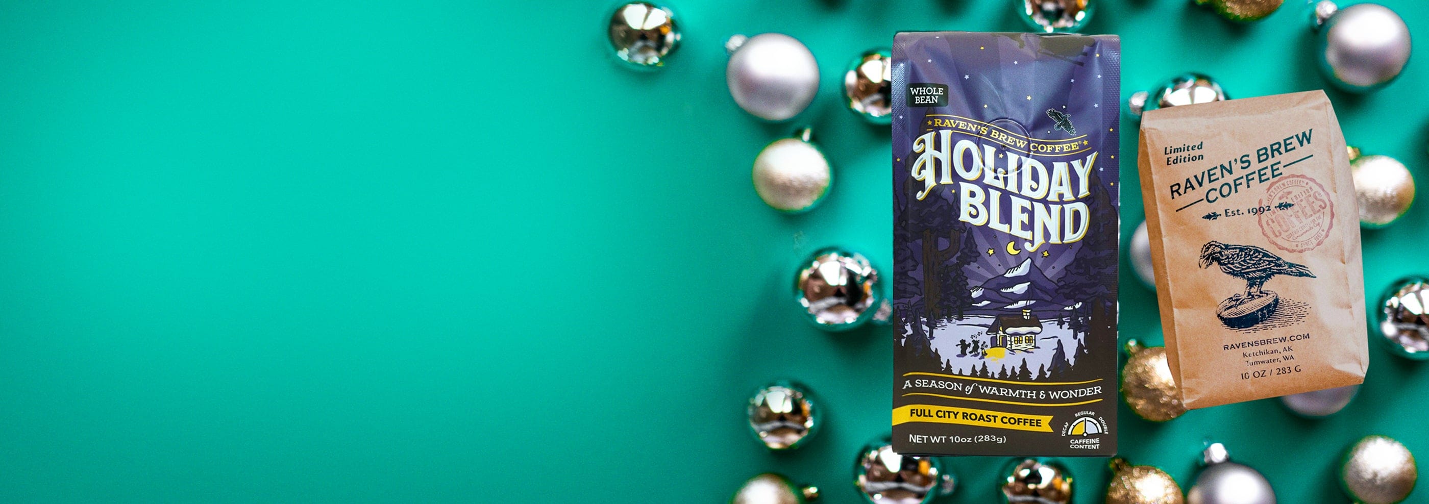 Festive Holiday Blend Coffee and Winter Solstice Coffee bags sitting on a green background surrounded by christmas baubles.